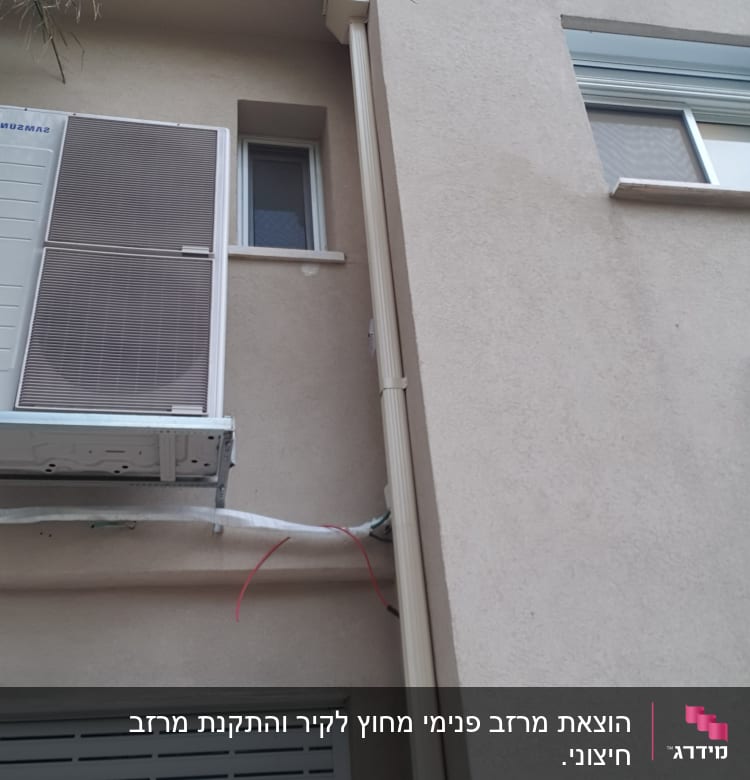מרזב מחובר לגג בניין עם צינור חשמל